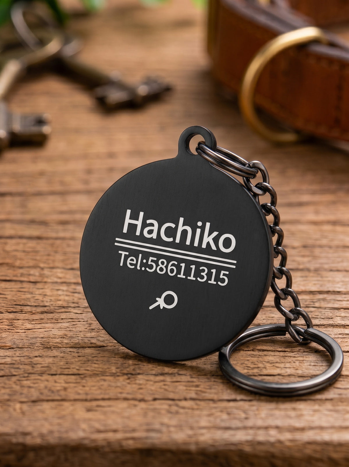 Black round dog ID tag engraved with name and phone number